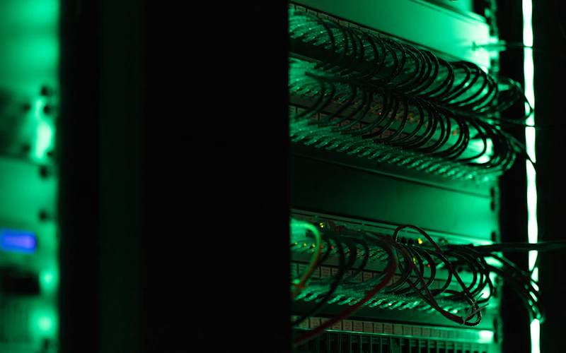 Network equipment lit green in a dark server room
